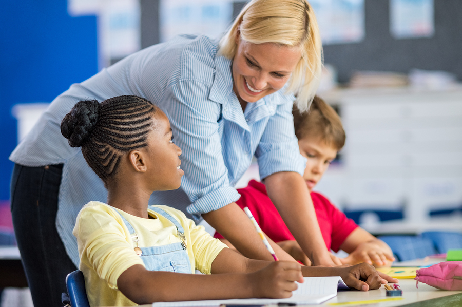 bigstock Happy teacher helping her stud 239207425 1